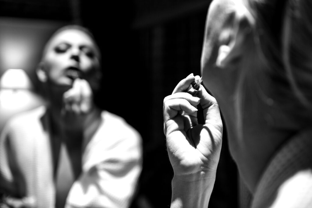 Porträt eines Künstlers in Schwarz-Weiß, Fokus auf Gesicht und Handhaltung.