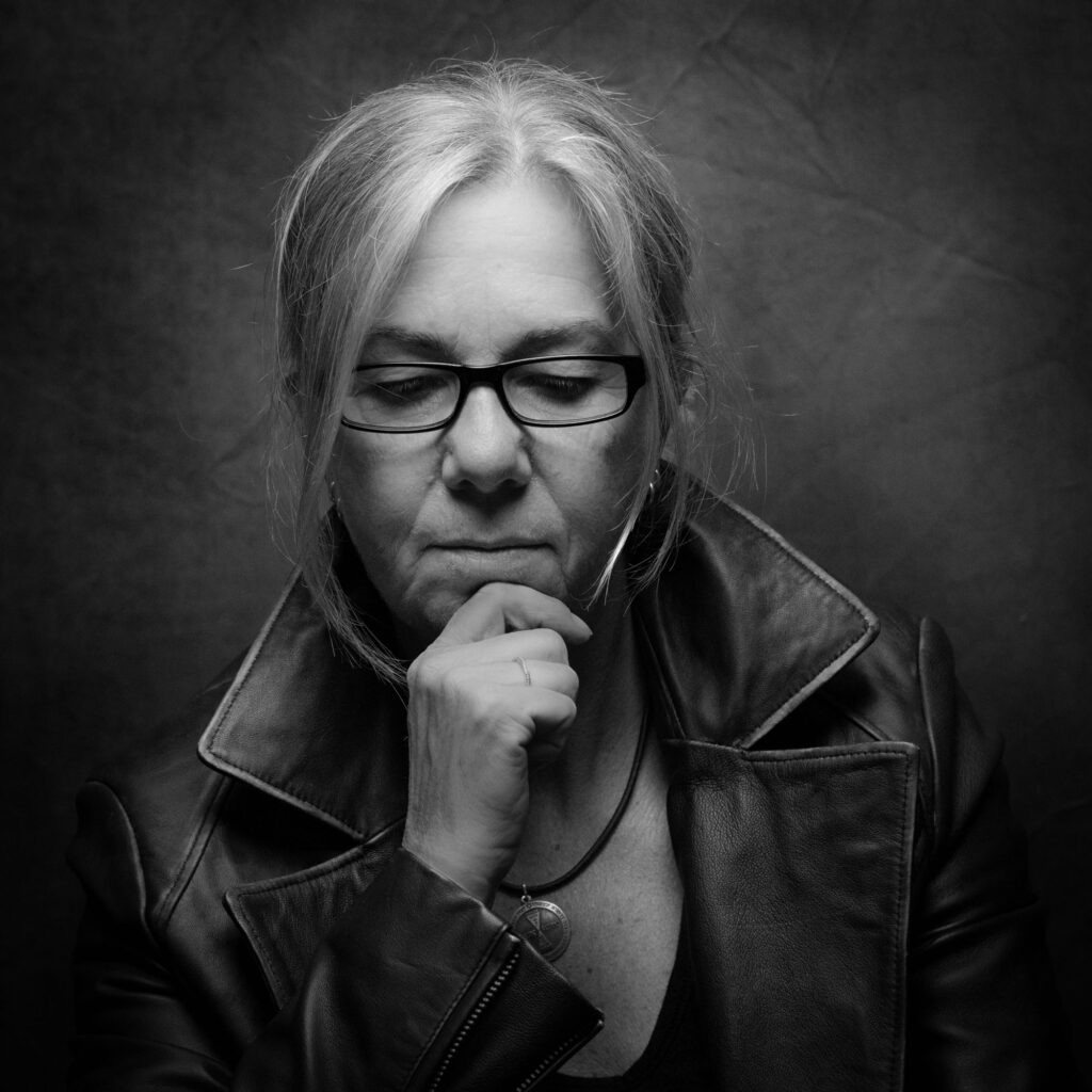 Nachdenkliches Porträt von Diane K Senft mit Brille in Lederjacke, die tief in Gedanken versunken ist, Selbstportät