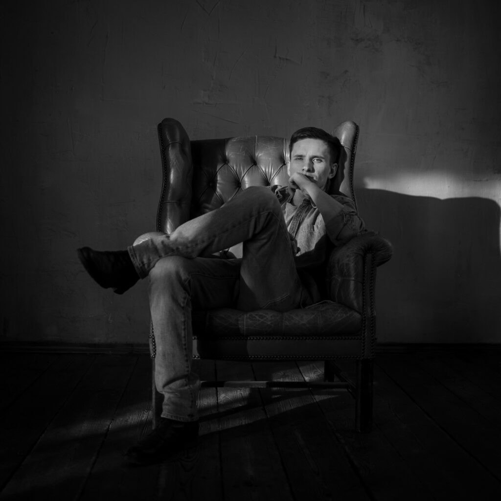 Künstlerisches Porträt von Diane K. Senft in Schwarz-Weiß, sitzend in einem Sessel.