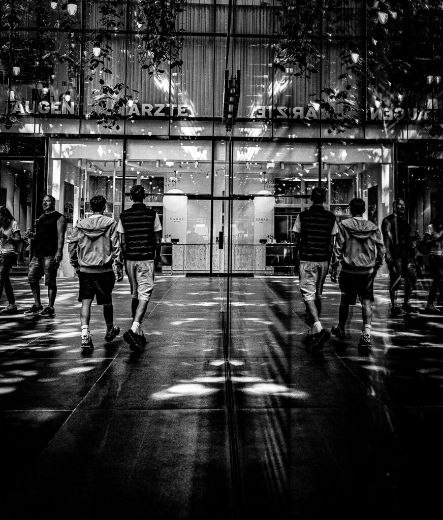 Menschen gehen auf einer beleuchteten Straße in der Stadt bei Nacht.