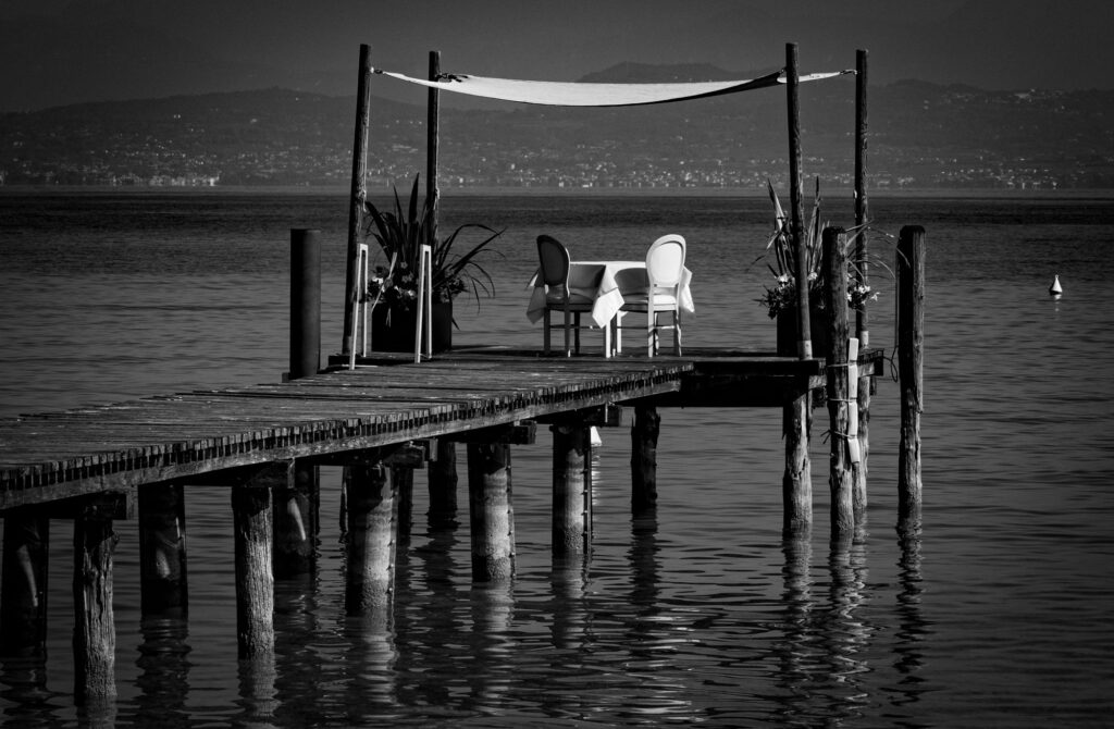 Stadtpier mit Stühlen und Dekoration am Wasser bei Sonnenuntergang. Street