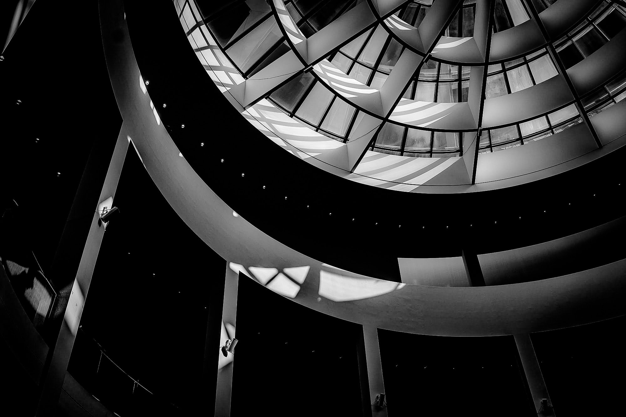 Blick nach oben auf spiralförmige Treppe in moderner Architektur. Streetfotografie Diane K. Senft