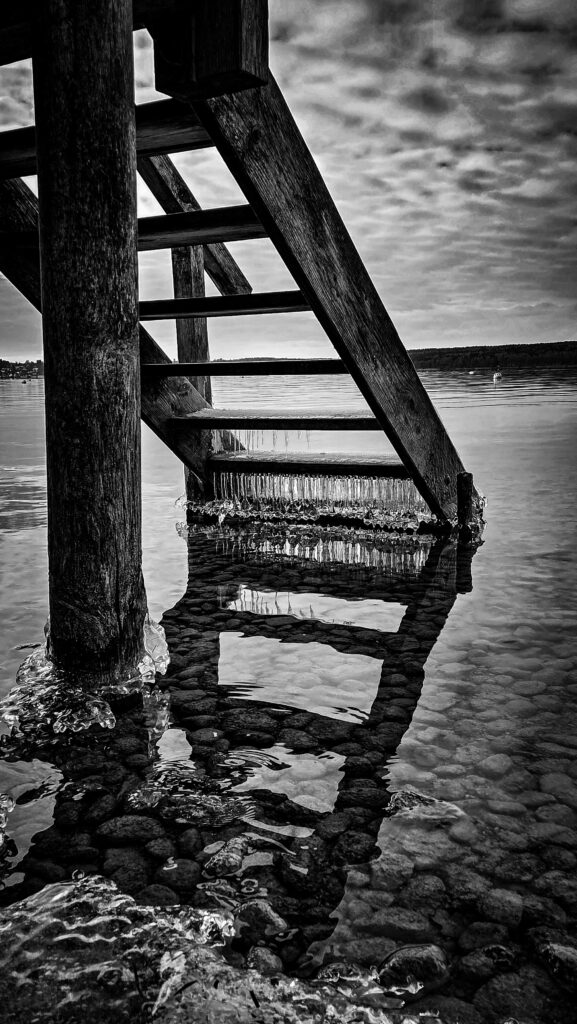 Holztreppe am Strand bei Ebbe, Blick auf das Meer und den Himmel.
